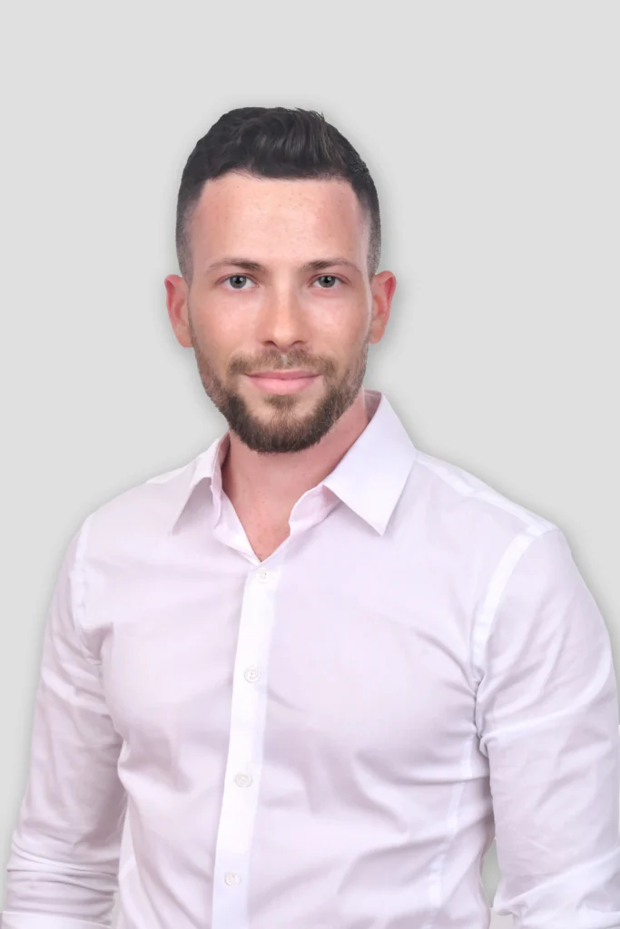 דיוקן של אדם לובש חולצה לבנה עם רקע אפור נקי