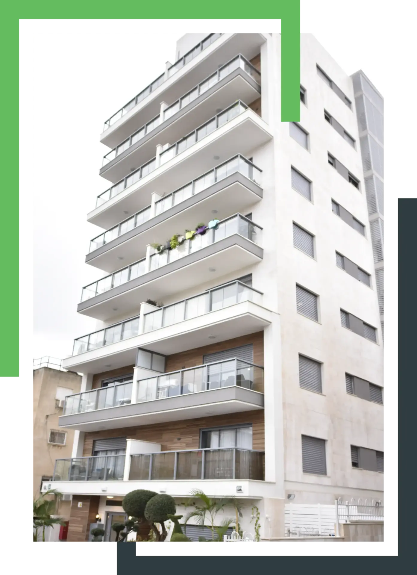בניין מגורים גבוה עם מרפסות זכוכית, עיצוב מודרני וצמחייה בחזית