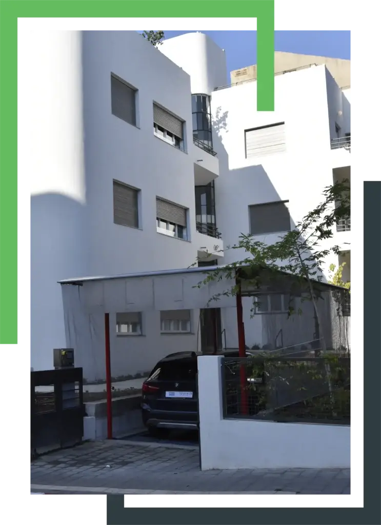 רכב יוצא ממערכת חנייה אוטומטית בחזית בניין מגורים עם עיצוב מודרני
